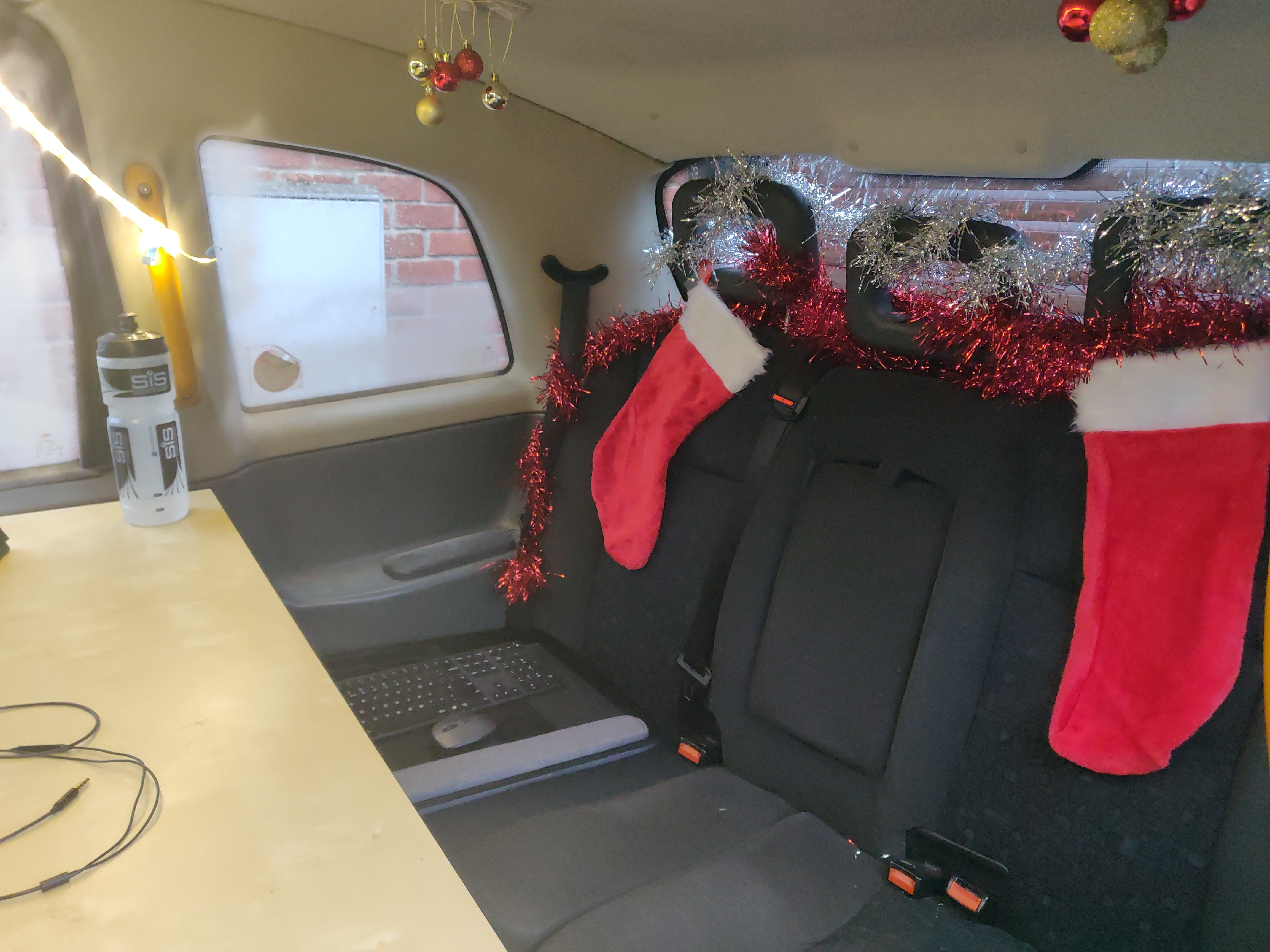 Photo taken from the open passenger door of the taxi, showing Christmas decorations in the back